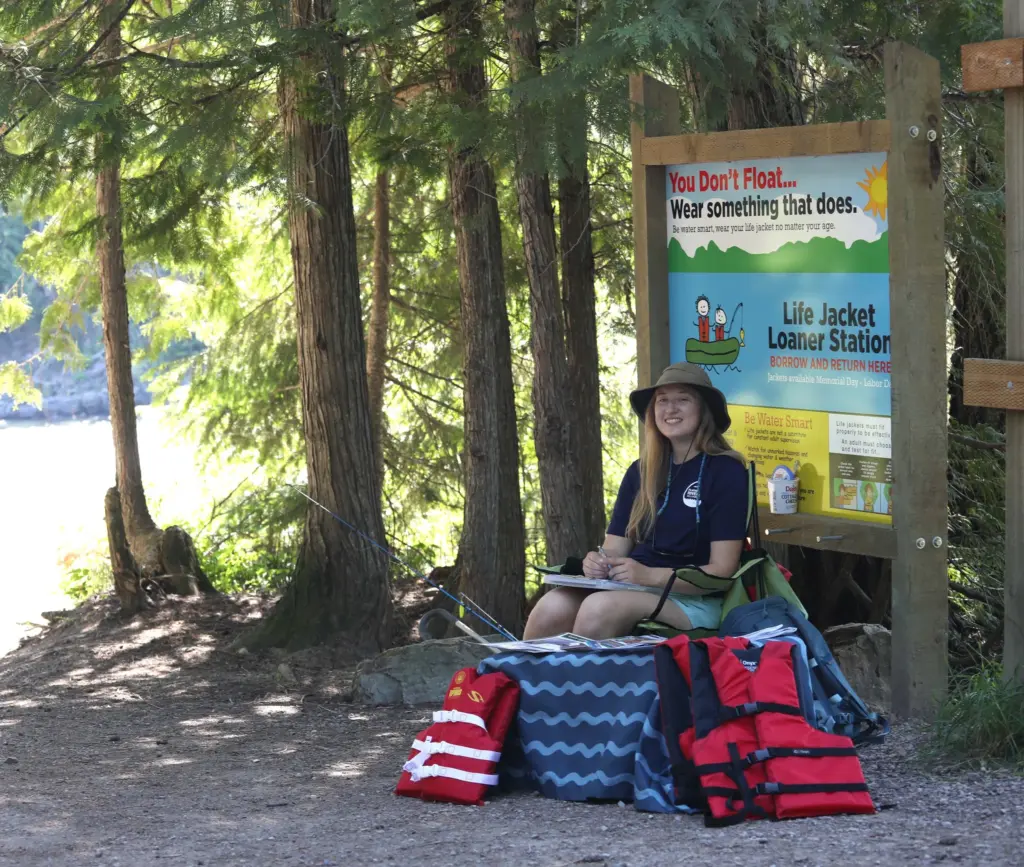 Andrea Getts, FRA River Ambassador, handing out loaner life jackets during volunteer shift at Glacier Rim River Access.